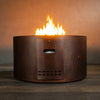 Front view of the Gravity Moreno 45-inch round copper fire pit by Starfire Designs, showcasing the lit flames and the integrated LP access door, emphasizing the convenience and elegant design of the fire pit.