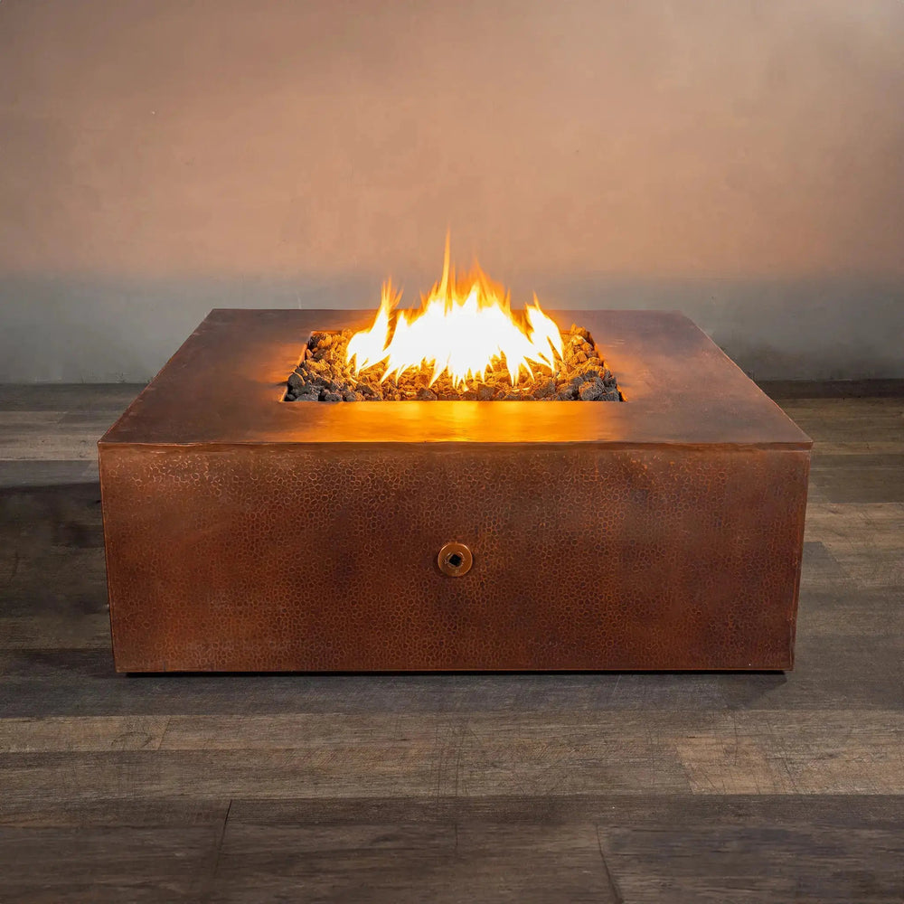 Gravity Moreno 45" W square copper fire pit by Starfire Designs, showcasing a beautiful flame on a bed of lava rocks, ideal for outdoor patio and backyard use, offering a luxurious and modern fire feature