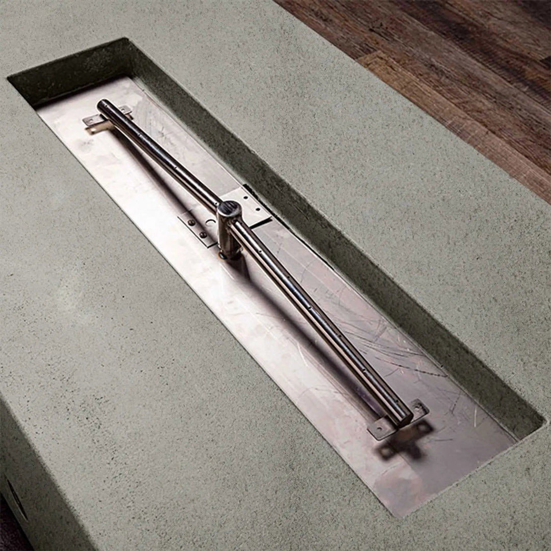 Close-up of the burner in Starfire Designs rustic 48-inch x 32-inch rectangle concrete gravity gas fire pit in natural gray, highlighting the durable burner design for outdoor fire pits