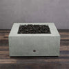 Back view of the Starfire Designs Rustic Gravity 36-inch Square Concrete Gas Fire Pit in Natural Gray, showcasing the durable concrete structure and natural lava rocks