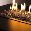 Reflective 1/2" Black Starfire Glass fire glass with flames dancing overhead. The black and mirrored surfaces provide a sophisticated, dramatic effect in any outdoor or backyard fire pit.