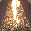 Warm-toned Bronze Reflective Starfire Glass in a close-up view, illuminated by flames. The earthy hues and shimmering finish create a cozy ambiance for backyard fire pits.