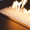 Elegant Clear Reflective Starfire Glass 1/2" Broken Fire Glass, glowing brightly under golden flames in a linear fire pit. Its shimmering clarity complements luxury fire pit designs.