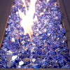 A close-up of Starfire Glass 1/2" Broken Cobalt Reflective Fire Glass (10lbs) glowing under bright flames. The deep blue cobalt glass pieces reflect the fire's glow, enhancing any outdoor fire pit, gas fire bowl, or modern fire pit setup.