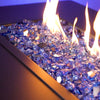 Starfire Glass 1/2" Broken Cobalt Reflective Fire Glass (10lbs) in a modern gas fire table. The brilliant blue glass sparkles against the warm flames, providing a luxurious aesthetic for backyard fire pits and outdoor gas fireplaces.

