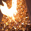 Starfire Glass 1/2" Broken Copper Reflective Fire Glass (10lbs) showing vibrant, rich amber tones under a dancing flame. Ideal for luxury fire pits, patio fire pits, and rectangular gas fire pits.