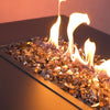 A modern fire pit table filled with Starfire Glass 1/2" Broken Copper Reflective Fire Glass (10lbs). The deep copper color reflects the flames beautifully, making it perfect for outdoor fire pit tables and freestanding fire pits.