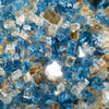 A detailed close-up of Starfire Glass 1/2" Broken Pre-Mixed Fire Glass in Pacific Sky, featuring a mesmerizing combination of light blue, clear, and gold-tinted reflective pieces. Perfect for modern fire pits, gas fire tables, and fire bowls, this glass creates a brilliant flame reflection for an upscale ambiance.