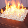 A copper fire table radiating warmth with clear Starfire Glass Reflective Fire Diamonds, producing bright, dancing flames. The reflective fire glass amplifies the firelight, making it an elegant addition to patio fire pits, modern gas fire pits, and luxury outdoor fire features.