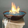 A breathtaking copper fire and water bowl with a cascading waterfall feature, filled with vibrant blue Starfire Glass Reflective Fire Drops. The unique combination of fire and water adds a luxurious touch, making it an excellent choice for a modern outdoor fire pit or fire bowls outdoor display.