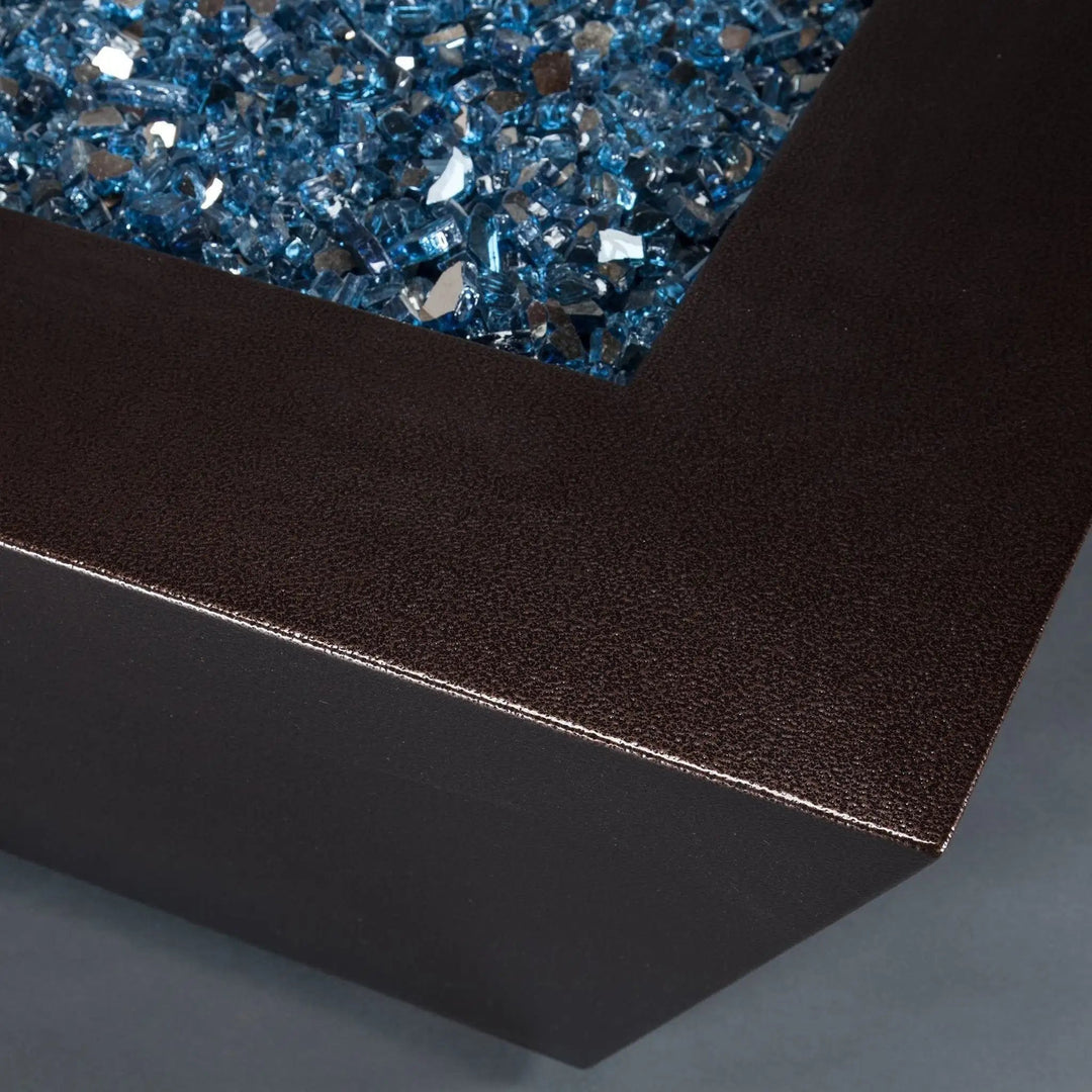 Close-up view of the corner detailing on the Steel Mill 72-inch by 38-inch Rectangle Gas Fire Pit in Copper Vein finish, showcasing the sleek design and fire glass. Ideal for modern outdoor spaces