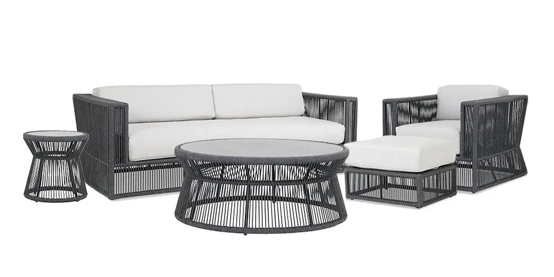 Modern outdoor furniture set featuring a woven rope design with a sofa, lounge chair, ottoman, round coffee table, and side table, all with light-colored cushions