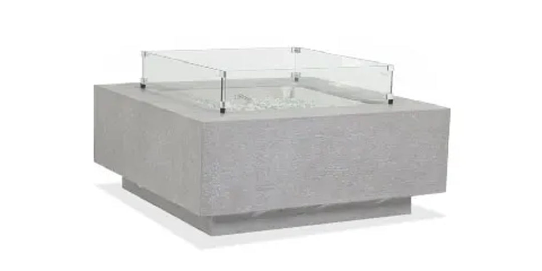 Modern square fire pit with a concrete finish and a clear glass wind guard, designed for outdoor use.