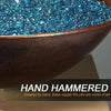 Close-up of the hand-hammered copper detail on the Taza Moreno 30-inch round copper fire and water bowl, highlighting the intricate craftsmanship with blue fire glass, a modern luxury fire pit for outdoor spaces by Starfire Designs
