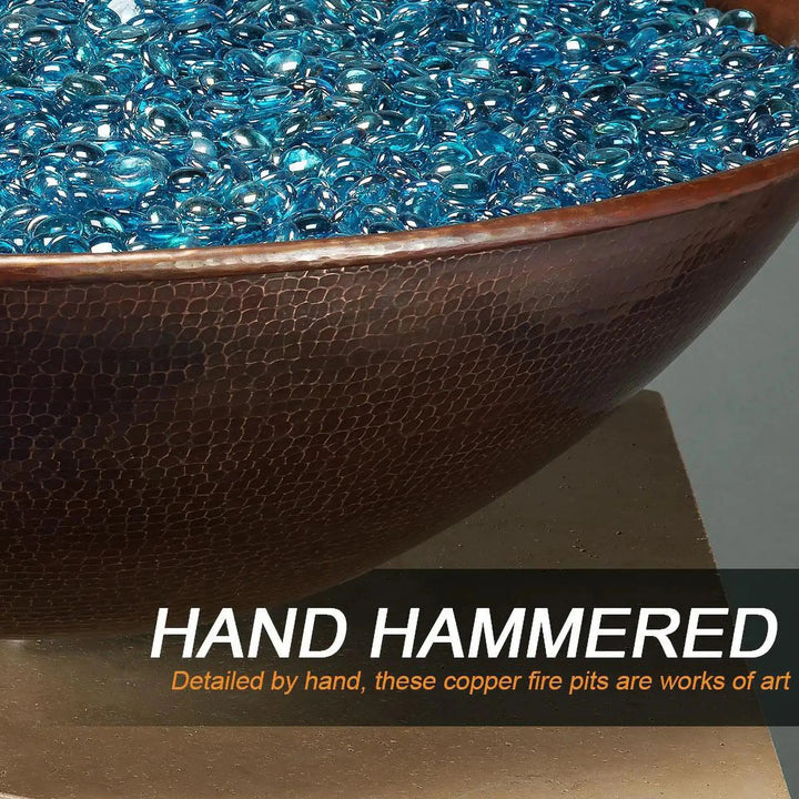 Close-up of the hand-hammered copper detail on the Taza Moreno 30-inch round copper fire and water bowl, highlighting the intricate craftsmanship with blue fire glass, a modern luxury fire pit for outdoor spaces by Starfire Designs