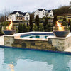 Two Outdoor Plus 27-inch Round Concrete Sedona Fire Bowls showcased poolside, offering a stylish addition to this outdoor living space. The clear glass guards surrounding the fire provide a chic and safe display, making these fire bowls perfect for entertaining. Ideal for luxury estates and outdoor spaces near water features, these fire bowls create an impressive aesthetic and atmosphere with glowing flames reflecting off the pool.
