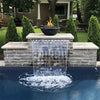 The Outdoor Plus 27-inch Round Concrete Sedona Fire Bowl featured above a waterfall display, adding a captivating element to this outdoor water feature. The fire bowl, with its sleek design, complements the flowing water, creating a striking contrast of fire and water in the backyard. Ideal for modern gardens and luxurious outdoor designs, this fire bowl provides a stunning focal point with its natural gas flames