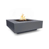 The Outdoor Plus 36-inch Cabo Square Concrete Gas Fire Pit in gray finish set in a modern outdoor environment. The sleek, square design and contemporary gray tone complement any modern patio. Includes a gas burner with lava rocks, creating a comfortable outdoor heating solution.