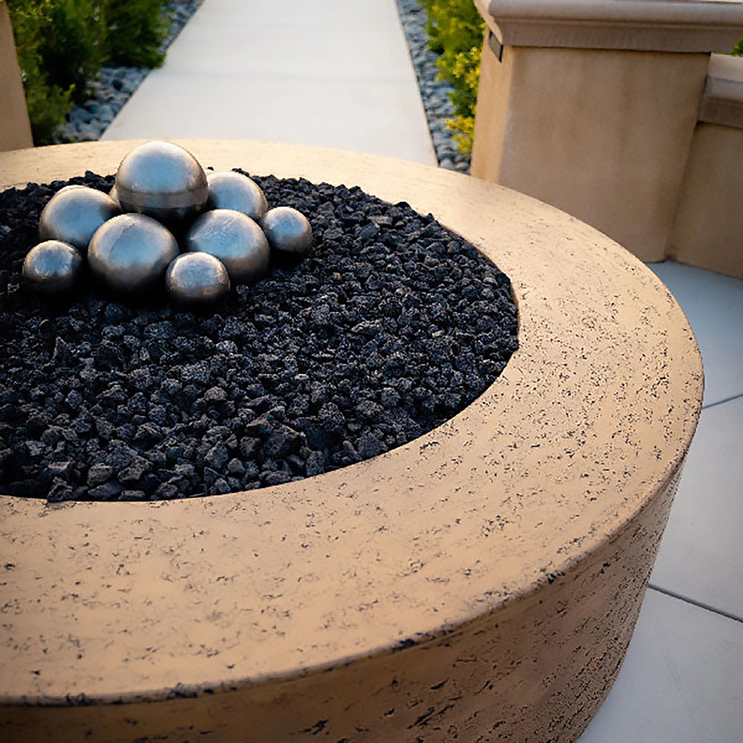 The Outdoor Plus 42-inch Occasional Height Florence Concrete Gas Fire Pit showcased on a wooden deck, providing a cozy and functional centerpiece for outdoor gatherings. This round fire pit features a durable concrete finish and a wide burner area, ideal for use with both natural gas and propane fuel types