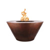 The Outdoor Plus 48-inch Martillo Copper Gas Fire Pit featuring a natural flame in a round, tapered design. This high-quality fire pit is made from premium copper, showcasing a rustic, hammered finish that develops a beautiful patina over time. The wide, flat-top rim provides an elegant contrast to the deep bowl, making it a centerpiece for any outdoor space. The image highlights the warm, inviting glow of the flame, perfect for enhancing backyard gatherings and patio settings. Ideal for use with natural ga