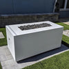 The Outdoor Plus 48-inch Pismo Concrete Gas Fire Pit in modern white finish, shown from the rear angle to display its sleek and solid concrete structure with hidden access panel for propane or gas connections. Set on a stylish paved patio, this fire pit combines aesthetics and functionality, making it a perfect centerpiece for any upscale outdoor entertainment area. 