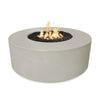 The Outdoor Plus 54-inch Occasional Height Florence Concrete Gas Fire Pit in ash color, showcasing a smooth, round design with a neutral light gray hue. This outdoor fire pit adds a contemporary touch to patios or backyard spaces, featuring a durable concrete body and a central fire bowl filled with lava rock, creating a striking ambiance. Ideal for enhancing outdoor gatherings with its modern elegance and premium build.