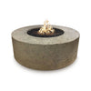 A stunning 54" Occasional Height Florence Concrete Gas Fire Pit in Moss Stone finish, showcasing its unique textured stone-like surface with earthy greenish tones. The circular design features a central burning area filled with black lava rocks, emitting a warm, inviting flame. This fire pit is perfect for any outdoor patio, backyard lounge, or luxury fire pit area, offering a durable and natural aesthetic.