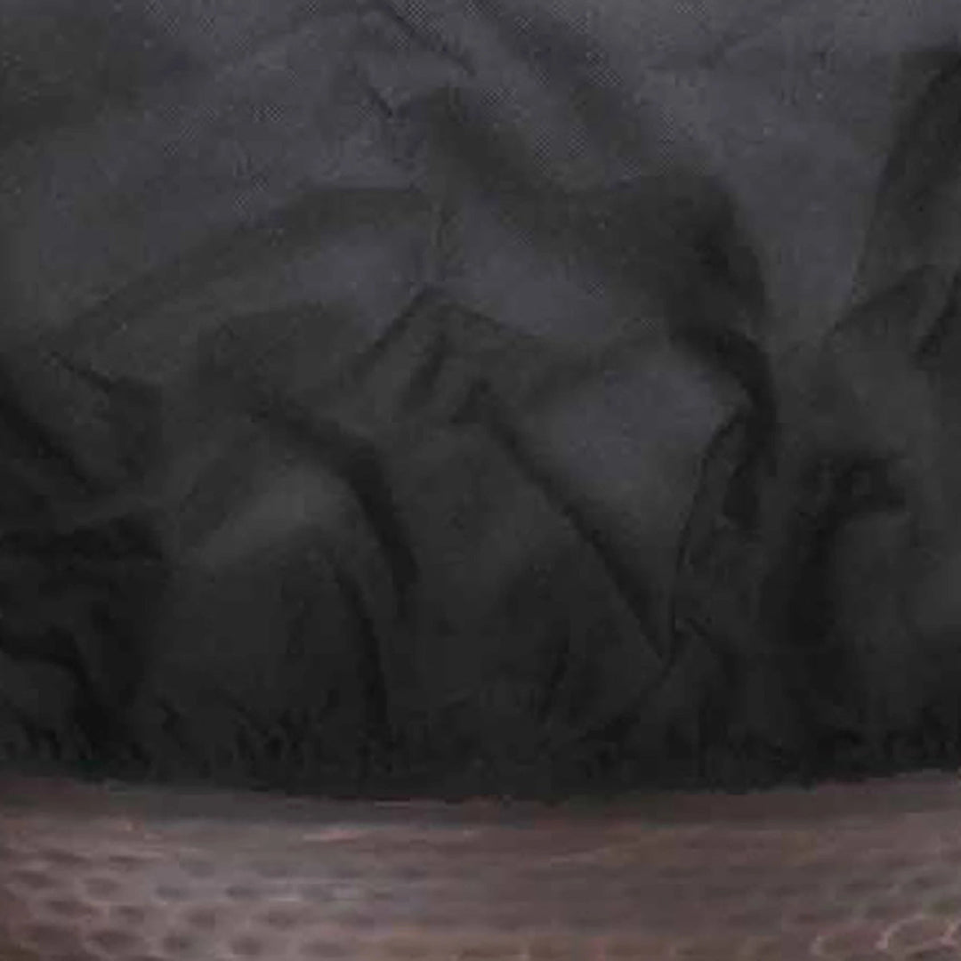 Close-up view of the fabric texture of The Outdoor Plus round bowl fire pit cover, highlighting the high-quality, tear-resistant black material that offers reliable protection against harsh weather conditions. The fabric's durable weave and waterproof properties make it ideal for preserving the finish of your fire pit. Perfect for preventing moisture and dust build-up.