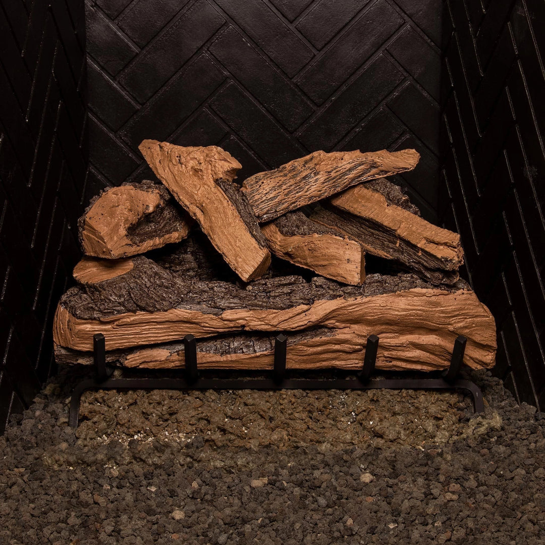 Side view of the Real Fyre Vented Designer Plus Gas Logs in split oak, unlit, showcasing the detailed bark texture and stacked log design on a black metal grate. The 24-inch log set offers a blend of large and small split oak logs, creating a natural and dynamic display for gas fireplaces. Suitable for vented setups, this set brings warmth and authenticity to indoor hearths.